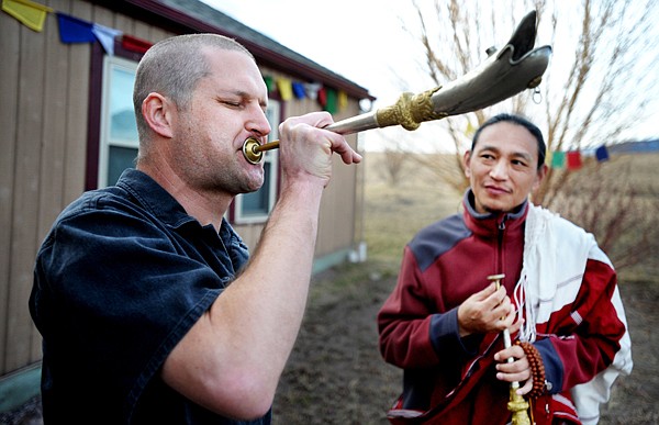 Jason Hicks of Victor practices with a Tibetan short horn as Lama Kunchok of Las Vegas looks on on Sunday in Arlee.