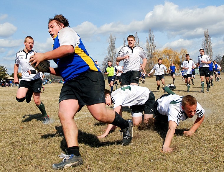 Dalton Hagen breaks away from a pack of Bitterroot Valley Warriors as he heads past the goal line (equivalent to end zone in American football) Saturday afternoon in Kalispell.