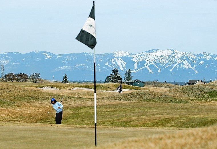 Tita Baldwin lets a shot fly toward the green at the Big Mountain Golf Club north of Kalispell on Thursday afternoon. There still may be skiing in the mountains, but golf courses in the valley are starting to open up.