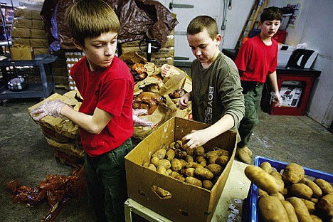 &lt;p&gt;Tyler Rieken, left, watches his behind-the-back shot go toward a bin as he and Brennan Jorgensen and Ryan Hinman, all 12, help sort potatoes Monday at the Community Action Partnership food bank in Coeur d'Alene. The trio was part of Boy Scout Troop 201 which volunteered a day of their spring break vacation to help out at the food bank cleaning, sorting and helping move items through the warehouse.&lt;/p&gt;