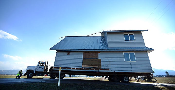 &lt;p&gt;Alex of D &amp; V Construction of Columbia Falls crouches as he guides the truck driver pulling a two story house under power lines as it pulls onto Wishart Road on Tuesday morning, March 29. The house is being moved to a new site on Sandy Hill Lane near Whitefish. (Brenda Ahearn/Daily Inter Lake)&lt;/p&gt;