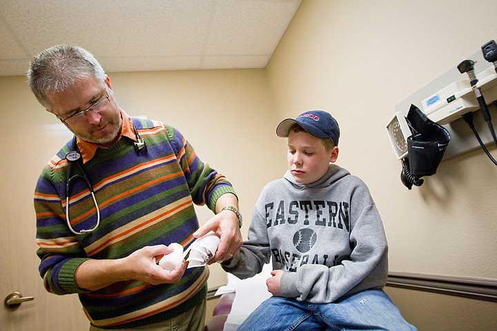 &lt;p&gt;Dr. Leonard Guth treats a burn on the hand of 14-year-old Tim Weingart, of Cataldo, Monday at After Hours Urgent Care in Coeur d'Alene. As of July 1, the minor emergency center, along with four others in the county, with continue services under the new name of Kootenai Urgent Care.&lt;/p&gt;