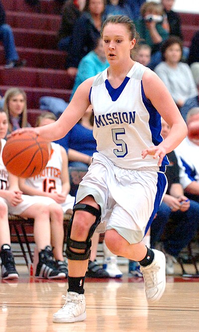 Mission's Kyla Mitchell pushes the ball up the court.