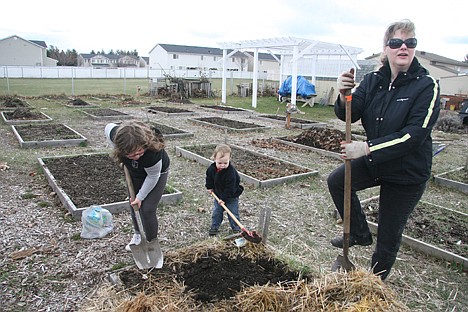 &lt;p&gt;From left, Mariah Anderson, 9, Nathan Babor, 2, and Michelle Gutz-Kleng of Coeur d'Alene do a little early-spring digging in the Community Garden of the Master on Saturday afternoon.&lt;/p&gt;