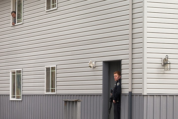 &lt;p&gt;SHAWN GUST/Press&lt;/p&gt;&lt;p&gt;JD Clark, an officer with the Idaho State Police, keeps a lookout on one exit of an apartment complex as a neighbor watches from his unit Thursday during a standoff with a wanted fugitive in Coeur d&#146;Alene. Fernan elementary School was locked down during the ordeal.&lt;/p&gt;
