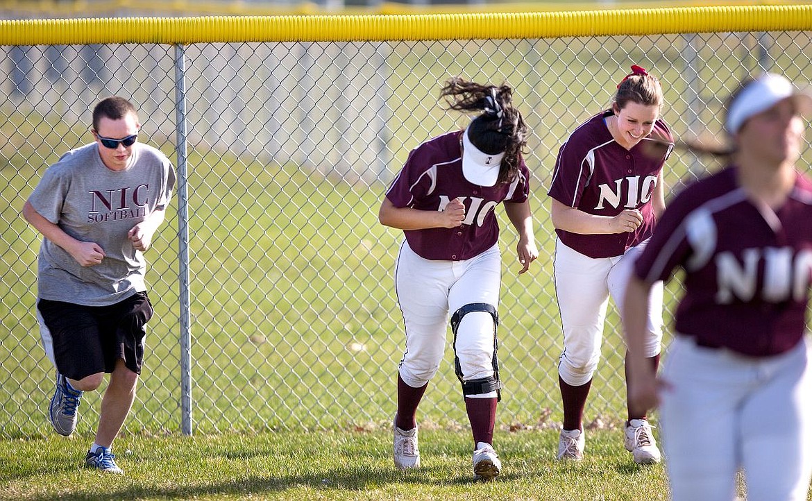 &lt;p&gt;R.J. Jay runs with North Idaho College softball players Jaymee Jackson, center, and Amber Hawkes, right, on Wednesday in between innings at a game against Columbia Basin College at Lake City High School.&lt;/p&gt;