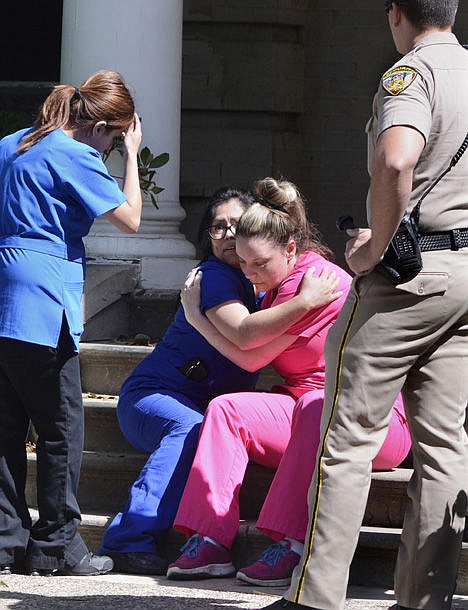 <p>Medical personnel comfort each other after being evacuated by Fresno Police at the scene of a shooting at a medical clinic Tuesday in Fresno, Calif. </p>