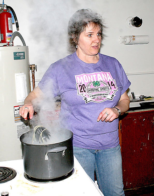 <p>Michele Parkin stirs a pot of spaghetti at the Superior 4-H building during the shooting sport spaghetti feed. The event was a fundraiser to send two shooters to the NRA National Championship.</p>