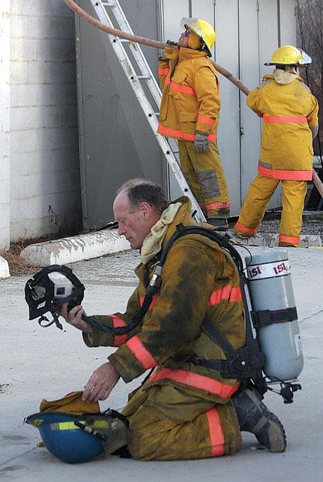 Photo By Aaric Bryan Hot Springs firefighter Wayne Lytton puts on his Self Contained Breathing Apparatus to go inside of The Running Iron Thursday in Hot Springs.