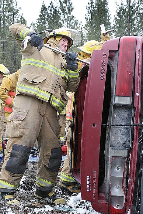 Photo by Adam Herrenbruck Brian Kirtley uses a hallagan tool to pry back the roof of a car the Plains-Paradise Rural Fire District and the Plains Fire Department were practicing on at the Valley Towing wrecking yard Saturday.