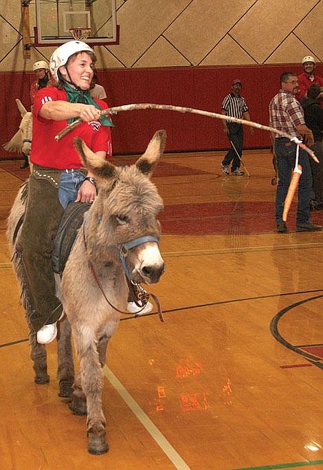 Photos by Aaric Bryan Cindy Moore tries to get her donkey to do what she wants it to by dangling a carrot in front of it Saturday at Noxon.