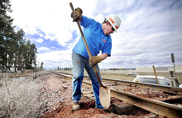 Jerry Carter of Twin Falls, Idaho, works to remove a rotted crosstie on the Kalispell subdivision railroad line Thursday along U.S. 2. Carter, operations specialist for West Region Watco Transportation, hoped to replace six ties before the afternoon trains came through.