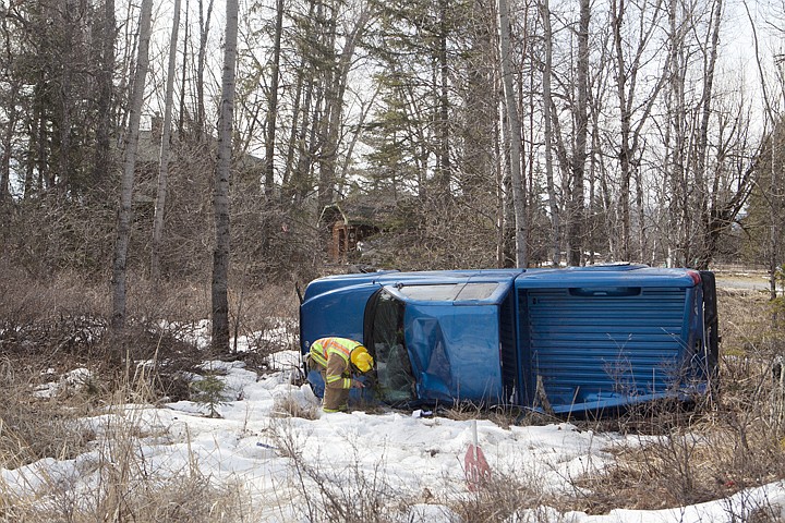 &lt;p&gt;A Bigfork firefighter looks inside the cab of a truck that rolled over off of Highway 83 Monday morning. The driver of the vehicle was transported to the hospital with minor injuries. Monday, March, 26, 2012 in Kalispell, Mont.&lt;/p&gt;
