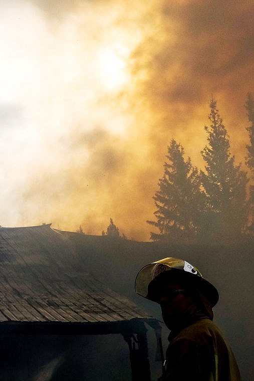 <p>Thick smoke blocks the sun as fire crews respond to a fully-engulfed home Friday morning on Truman Creek Road near Kila . April 4, 2014 in Kila, Montana. (Patrick Cote/Daily Inter Lake)</p>
