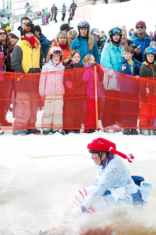 <p>Spectators watch as Cody McCarthy, dressed as Raggedy Andy, flies by Saturday afternoon during the 9th Annual Whitefish Mountain Resort Pond Skim. April 5, 2014 in Whitefish, Montana. (Patrick Cote/Daily Inter Lake)</p>