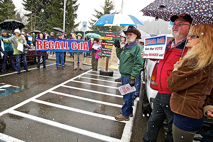 &lt;p&gt;JEROME A. POLLOS/Press Jeff and Pam Tyler stand under their umbrella as supporters of a recall of Coeur d'Alene's mayor and half of the city council chant outside of city hall Wednesday.&lt;/p&gt;