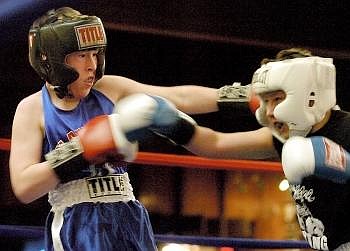 Flathead boxer Calvin Steiner, left, throws a hook at Guage Anderson, of Spokane Boxing Club, in the 100-pound weight division Saturday night at the Kalispell Elks Lodge. Anderson won by a decision. Allison Money photos/Daily Inter Lake