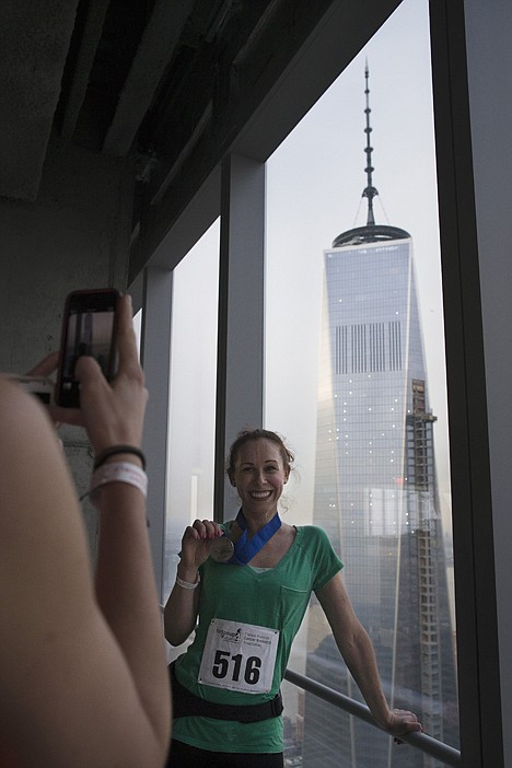 <p>A runner shows off her medal on the 72nd floor of 4 World Trade Center during the "Runyon Up," Thursday, in New York.</p>