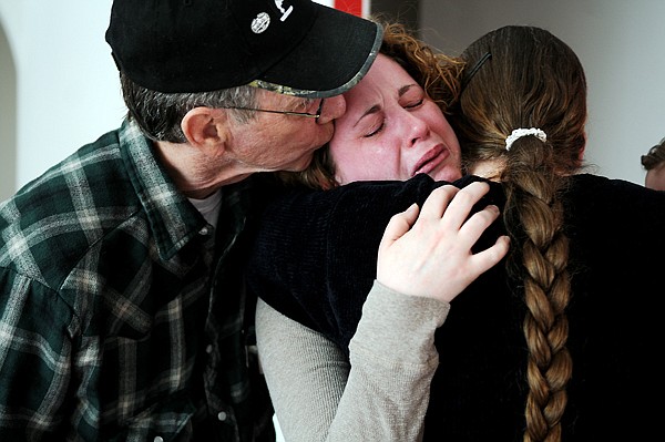 <p>An emotional Juliane White gets a hug from her mother, Ann, and a kiss from her father, O.T. Green, Wednesday afternoon in her new home in Lakeside. White’s husband, Kevin, died in his sleep Sunday, just two weeks before they were set to move in.</p>