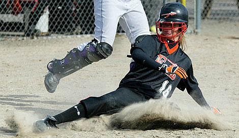 Flathead junior center fielder Heather Haegele slides home in the bottom of the fifth inning Thursday during the Bravettes&#146; softball game against Missoula Sentinel at the Conrad Complex. Haegele had two of the Bravettes&#146; four hits, and stole two bases, to help lead Flathead to a 4-2 Western AA victory. Craig Moore/Daily Inter Lake