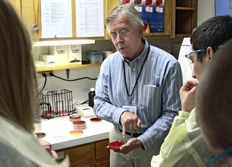 Tom Olding shows the students what a staph infection looks like in a petri dish, which is to be looked at under a microscope.  Olding manages the labratory at Clark Fork Valley Hospital.