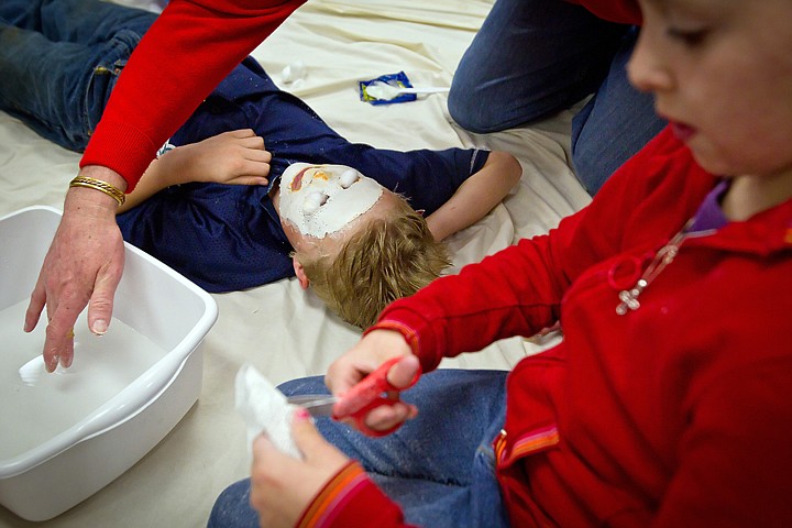 &lt;p&gt;Zach Sensel, 9, relaxes as he has his mask molded to his face and Rikki Hickman, 11, cuts fabric for her mask.&lt;/p&gt;