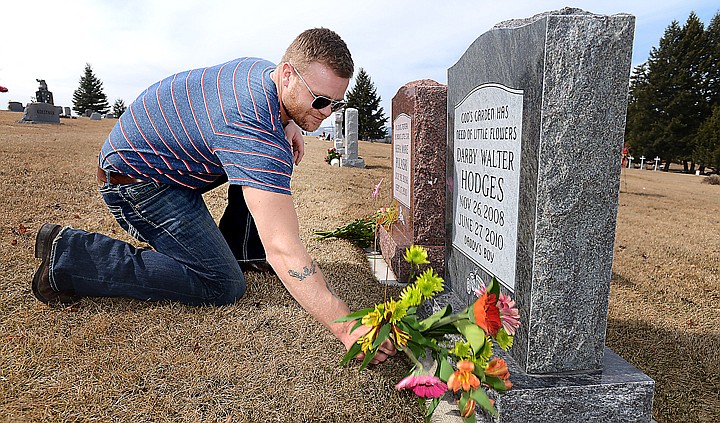 &lt;p&gt;Tommy Hodges, father to Darby and stepfather to Kiera, lays flowers at their graves on&#160; March 25 at Conrad Memorial Cemetery in Kalispell. (Brenda Ahearn/Daily Inter Lake)&lt;/p&gt;