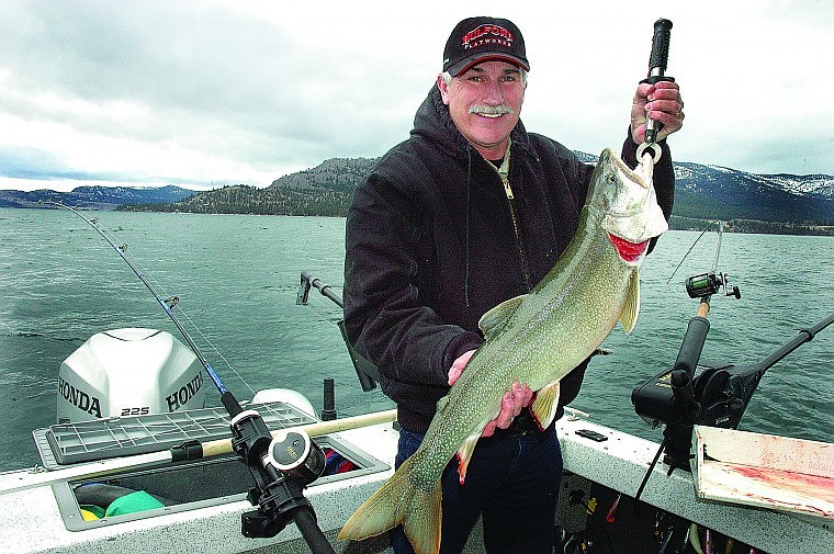 Lee Selders holds a lake trout last Thursday on Flathead Lake. In the background is Wild Horse Island.
