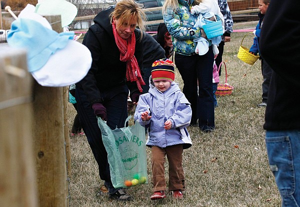 Triss Lindberg, of Proctor, walks with her daughter Ula Saturday during the four years and under Easter Egg Hunt at Dayton Park.