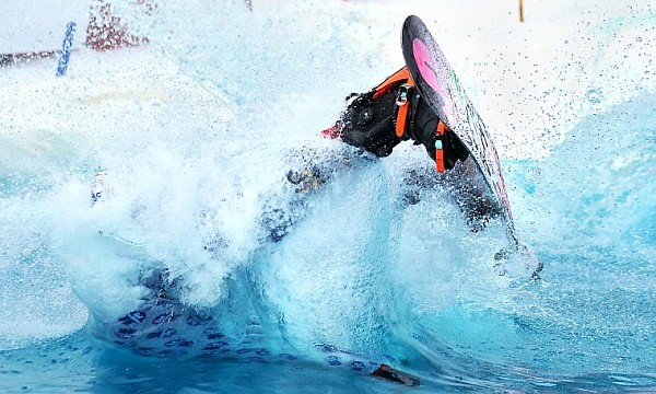 Brett Urbach flips through the air before going into a man-made pond on Saturday afternoon during the sixth annual Pond Skim at Whitefish Mountain Resort at Big Mountain. The vent marks the end of the ski season on the hill.