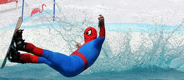 Spiderman leans back in mid-air a split second before hitting the water's surface.
