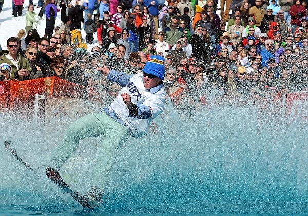 A participant leans back and attempts to keep his balance and beer from spilling as he zooms across the water.