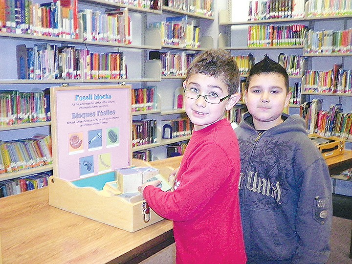 Two Knolls Vista Elementary School students pause in between working with fossil blocks during the Pacific Science Center's visit to the school.