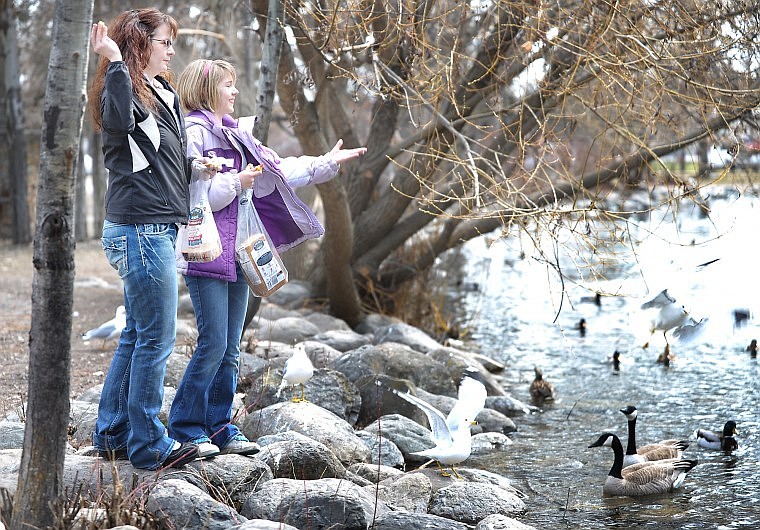 Jennifer Lamkin of Kalispell and her 12-year-old daughter Sydney feed the birds and waterfowl at Woodland Park in Kalispell on Monday.