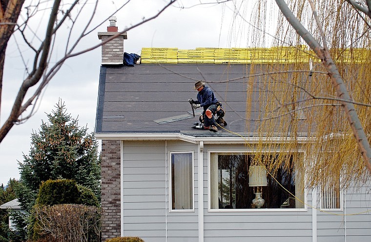 Conor Davison works on re-roofing a home on Country Way North in Kalispell on Wednesday afternoon.