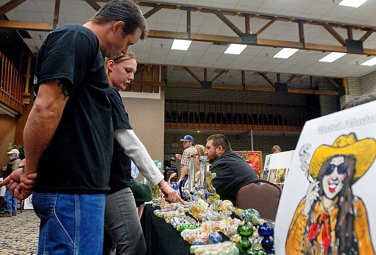 Tammey Strickrodt points out some pipes to her husband, Jack, at the Outlaw Inn on Tuesday afternoon. More than two dozen booths, mostly with local vendors, were set up while the Montana Caregivers Network put on a public clinic for people to enroll in Montana&#146;s Medical Marijuana Program.