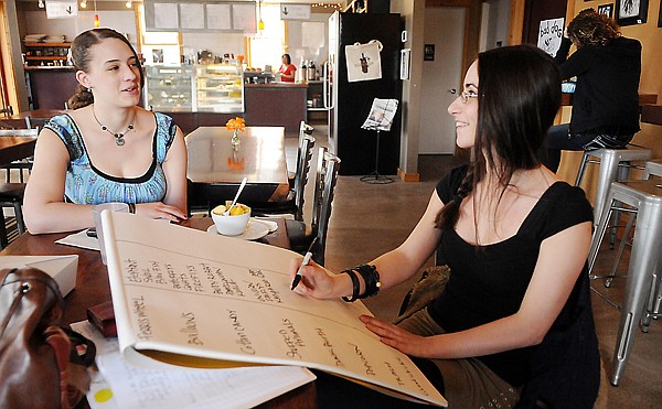 Leigh Ann DiDomenico, right, and Rosie Davis, left, complete a writing exercise during the workshop prior to the GET POETRY Open Mic on Sunday, April 3, at the Boiler Room.