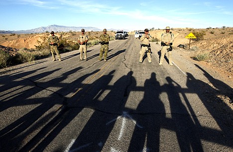 &lt;p&gt;Federal law enforcement officers block a road at the Lake Mead National Recreation Area near Overton, Nev. Thursday. In the foreground are the shadows of protestors. Two people were detained while protesting the roundup of cattle owned by Cliven Bundy on the road.&lt;/p&gt;