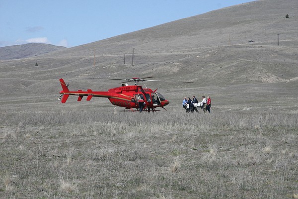 Emergency personnel prepare to load Shane Steffans, 24, into an ALERT helicopter to medevac him to a hospital in Kalispell. Steffans was the lone survivor in a single car wreck that killed two others.