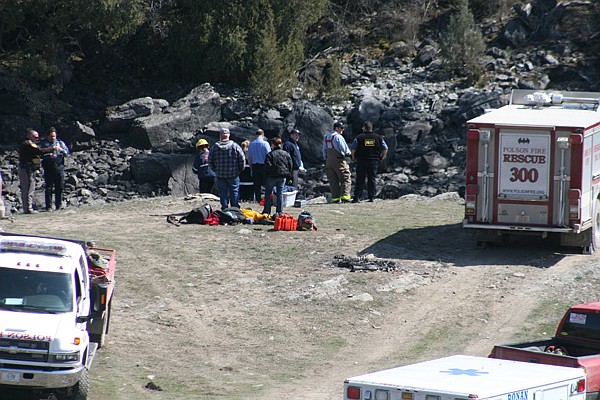 Emergency personnel evaluate the scene of a single car wreck at campsite on the Flathead River. The vehicle fell from a 25-foot cliff into the frigid river water.