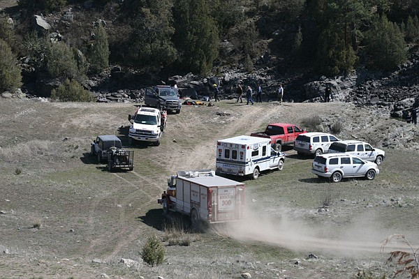 Emergency personnel evaluate the scene of a single car wreck at campsite on the Flathead River. The vehicle fell from a 25-foot cliff into the frigid river water. Two men were killed in the accident while the alleged driver survived.