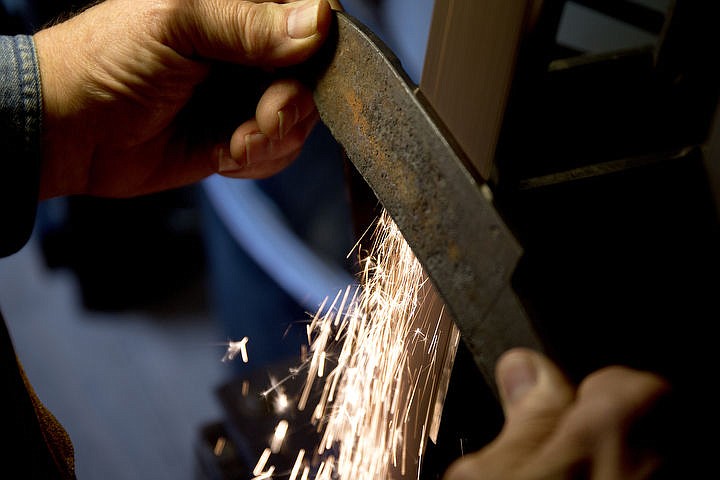 &lt;p&gt;Using a belt sander, Mike Mann grinds down a recycled steel leaf spring to make a knife blade.&lt;/p&gt;