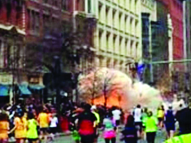 <p>In this image from video provided by WBZ TV, spectators and runners run from what was described as twin explosions that shook the finish line of the Boston Marathon, Monday, April 15, 2013, in Boston. Two explosions shattered the euphoria of the Boston Marathon finish line on Monday, sending authorities out on the course to carry off the injured while the stragglers were rerouted away from the smoking site of the blasts. (AP Photo/WBZTV)</p>