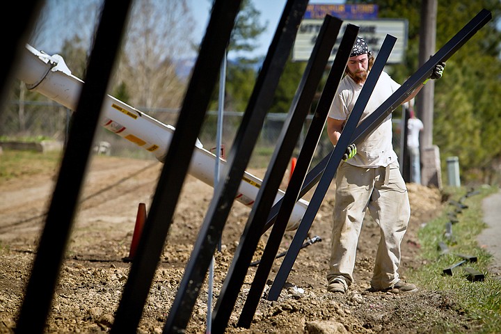 &lt;p&gt;John McBenge, with Northwest Fence, moves metal fencing post while pouring concrete Thursday at the Pinegrove Cemetery in Rathdrum. The 600 feet of a new wrought-iron fence along the historic cemetery's front section on Highway 53 is the latest improvement to the cemetery.&lt;/p&gt;