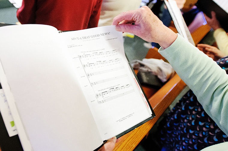 <p>Mary Bond flips through her song book during an April 11 rehearsal for the Columbia Falls Community Choir at the United Methodist Church in Columbia Falls.</p>