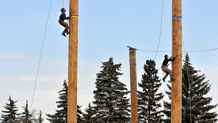 Flathead Valley Community College's Gavin Lommatsch (left) races up a pole against the University of Montana's Dan Pickar during Stumpjumper Days at FVCC's Logger Sports Arena Saturday afternoon.