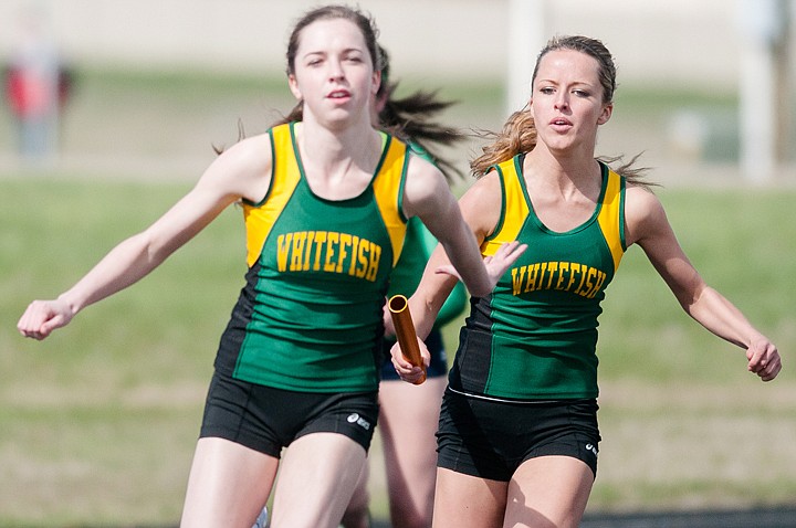 <p>Whitefish’s Amanda Foley, right, hands the baton to Amarlow Shulz during the 400-meter relay at Glacier High School Tuesday.</p>