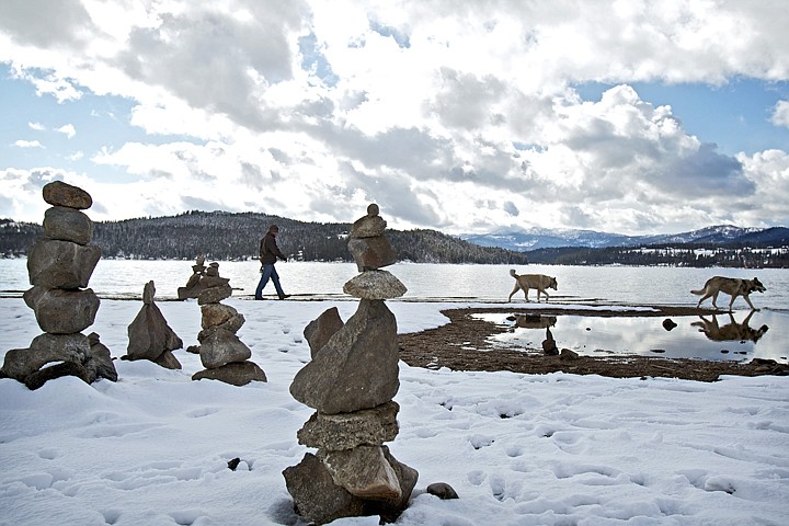 &lt;p&gt;JEROME A. POLLOS/Press Justice Daniels, walks his dogs, Merlin and Baloo, during an outing Thursday along the shoreline of Lake Coeur d'Alene near North Idaho College where a number of rocks stacks have been constructed on the beach.&lt;/p&gt;