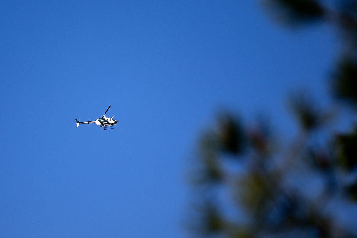<p>Spokane County's Air One helicopter scours the Cougar Gulch area on Tuesday for a man who allegedly led the police on a car chase that spurred gunfire and the suspect ramming an Idaho State Police vehicle.</p>