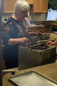 Loretta Jessop, a truffle making volunteer, dips the candies in a chocolate layer during the fund raising event last Wednesday.